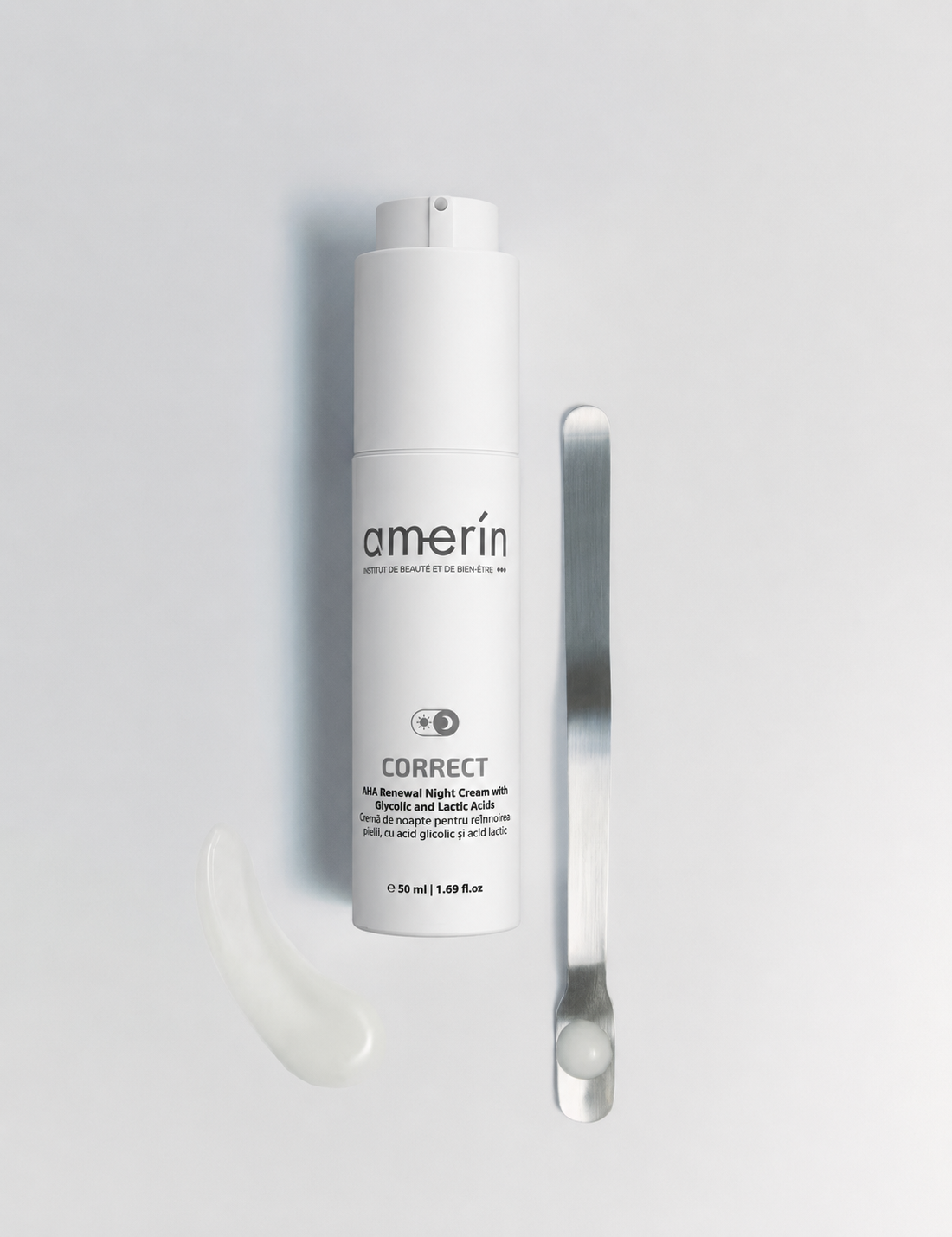 A AHA Renewal Night Cream with Glycolic and Lactic Acids bottle with a white applicator tip, shown on a light gray background next to a silver spatula and a small smear of white cream.