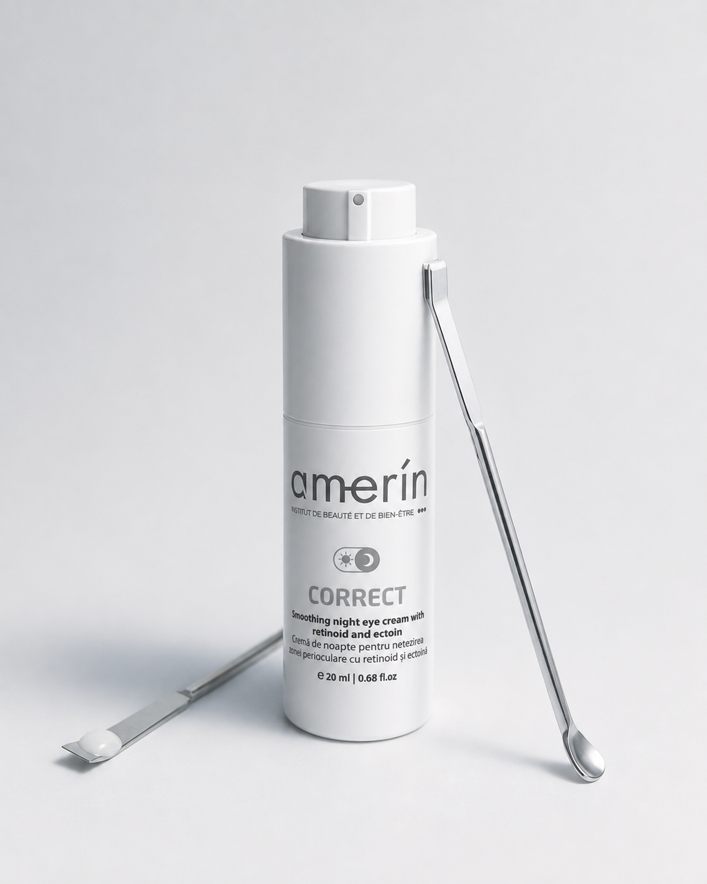 A white cylindrical cosmetic bottle labeled amerín CORRECT smoothing night eye cream, shown on a light gray studio background with two silver metal spatula tools placed beside it.