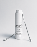 A white cylindrical cosmetic bottle labeled amerín CORRECT smoothing night eye cream, shown on a light gray studio background with two silver metal spatula tools placed beside it.